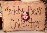 small quilted look decorative pillow with the words "Teddy Bear Collector" stitched on front as well as an adorable teddy bear button 